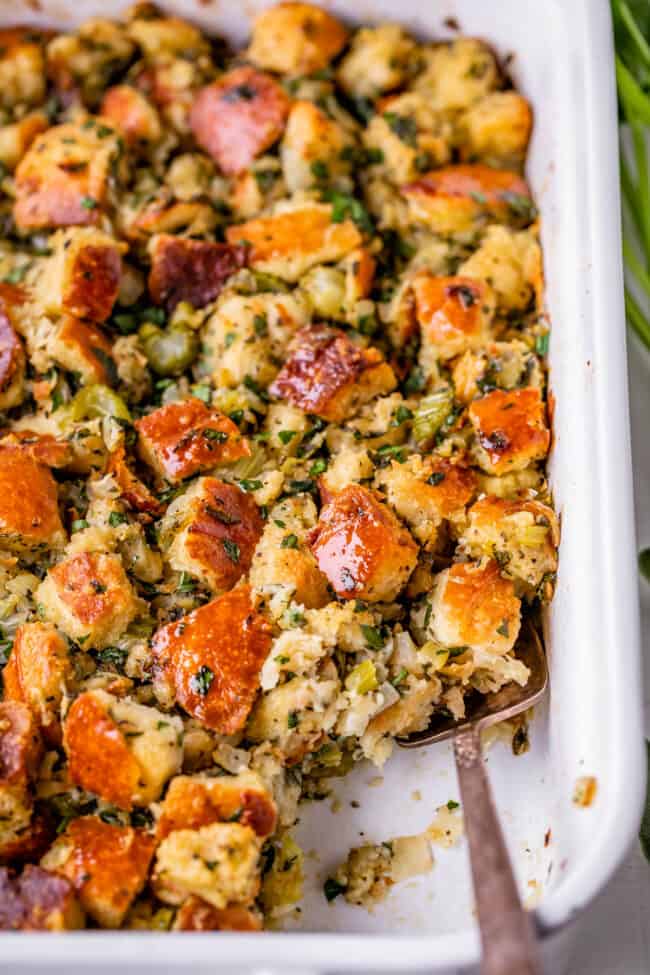 thanksgiving stuffing recipe in a white casserole dish with spoon