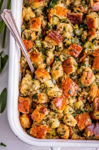 thanksgiving stuffing in a white dish with a spoon, over head
