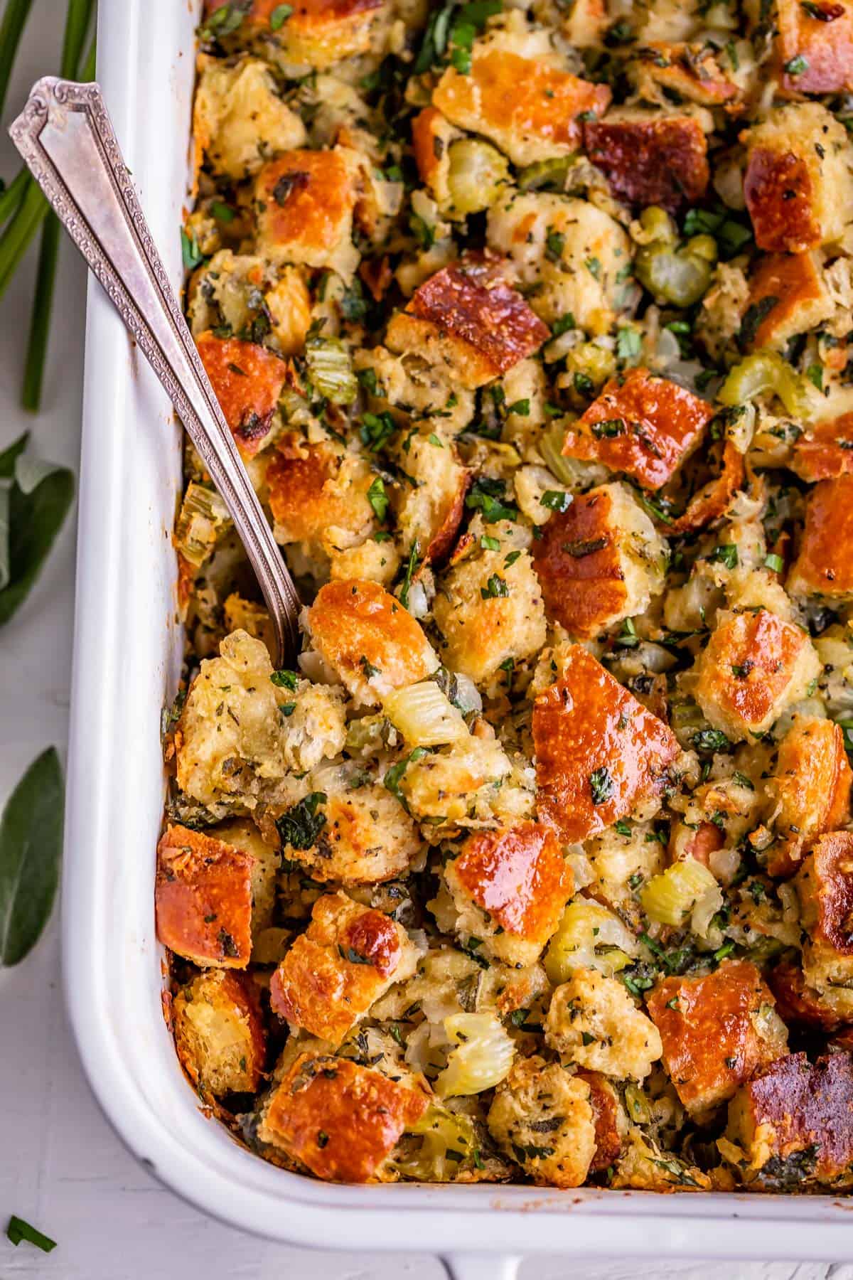 thanksgiving stuffing in a white dish with a spoon, over head