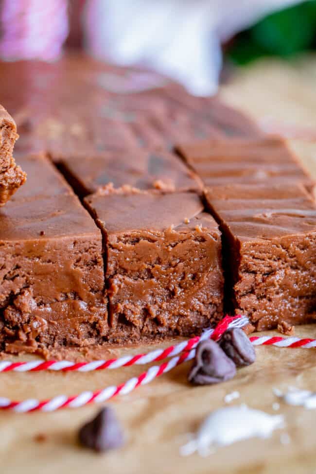 fudge cut into square on parchment paper, chocolate chips and red string.