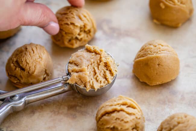 peanut butter cookie dough in balls and dough in a cookie scoop.