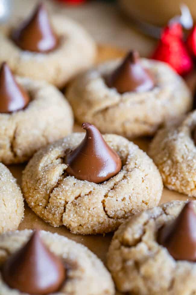 peanut butter blossoms recipe with cookies lined up on parchment paper