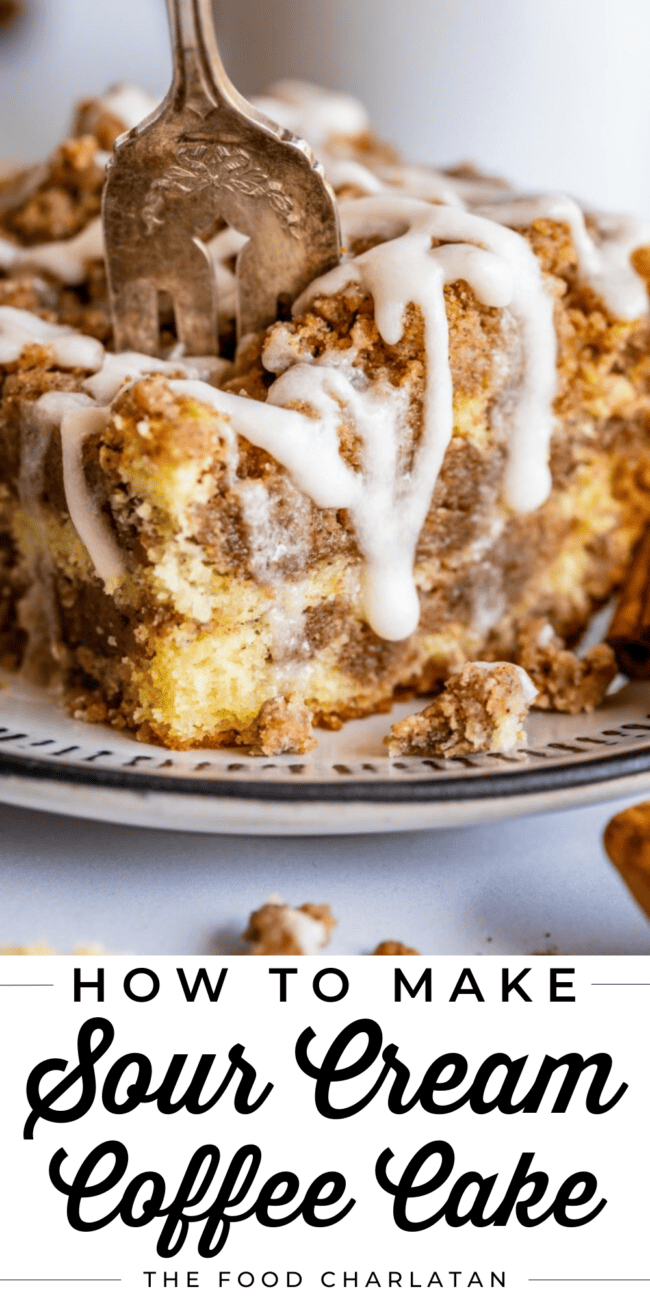 a thick slice of sour cream coffee cake with vanilla glaze and a fork stuck in it.