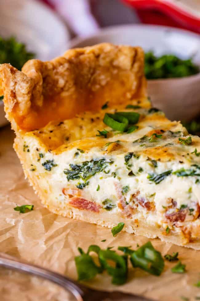 quiche recipe with spinach and bacon, sliced on parchment paper