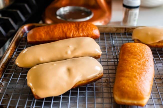 glazed and unglazed maple donuts on a cooling rack