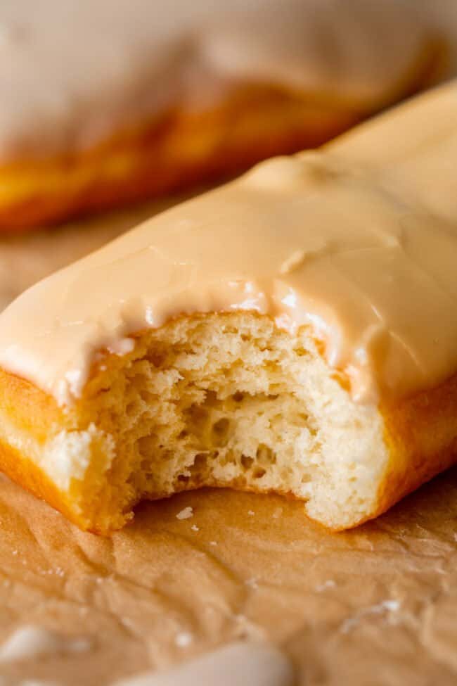 maple donut with maple glaze on tray, bite taken