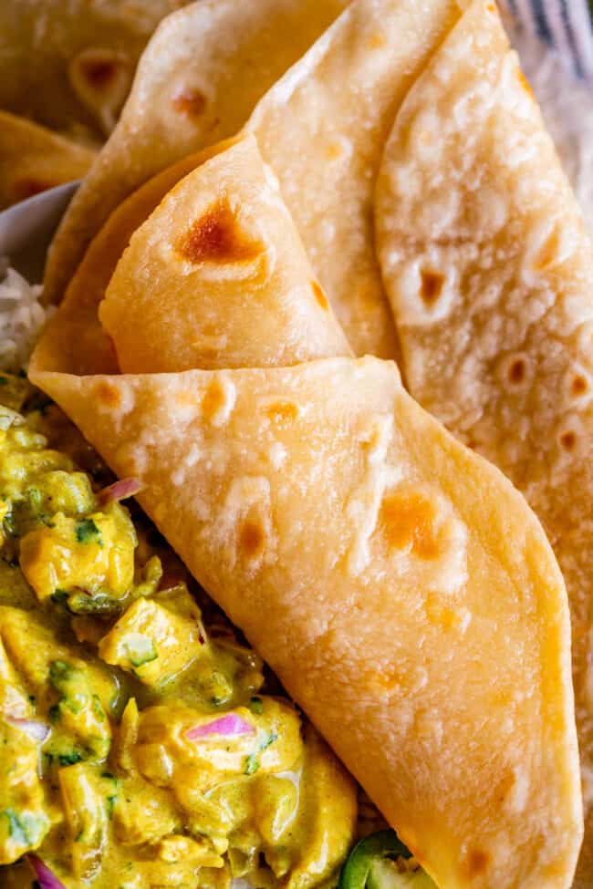 rolled indian flatbread on a plate with yellow curry