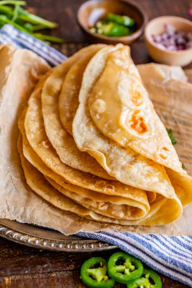 Indian roti bread on a metal plate with blue napkin and parchment paper