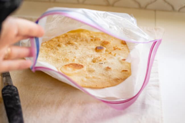 roti bread steaming in a ziplock bag with paper towels