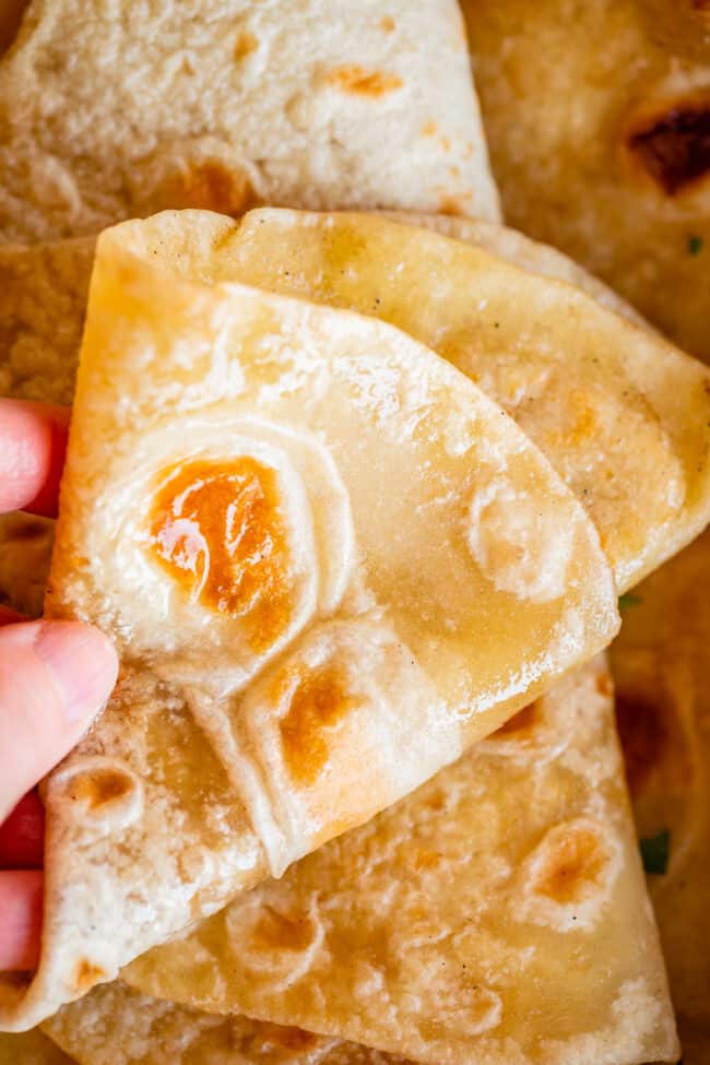 hand moving roti indian bread to show softness