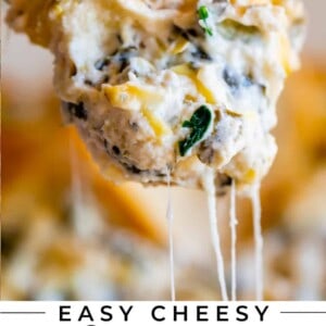 hand holding a piece of toast dipped in easy spinach artichoke dip