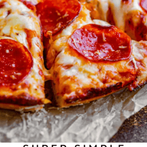 Close-up of sliced pepperoni pizza with melted cheese on parchment paper. Below, text reads: Super Simple Beginners Pizza Dough - The Food Charlatan, featuring a golden crust and savory toppings.
