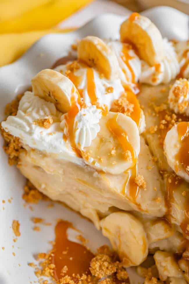 overhead shot of slice of best banana cream pie drizzled with caramel.