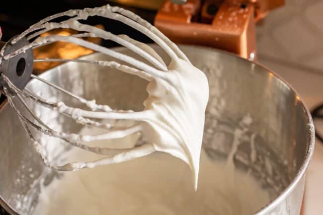 whipped cream on the whisk attachment of a stand mixer.