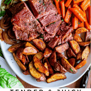 crockpot corned beef on a large platter with carrots potatoes and cabbage