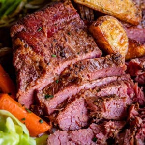 sliced corned beef and cabbage on a plate with potatoes and carrots