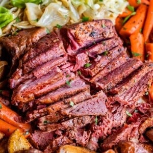 corned beef recipe, sliced on a platter with potatoes, carrots, and cabbage