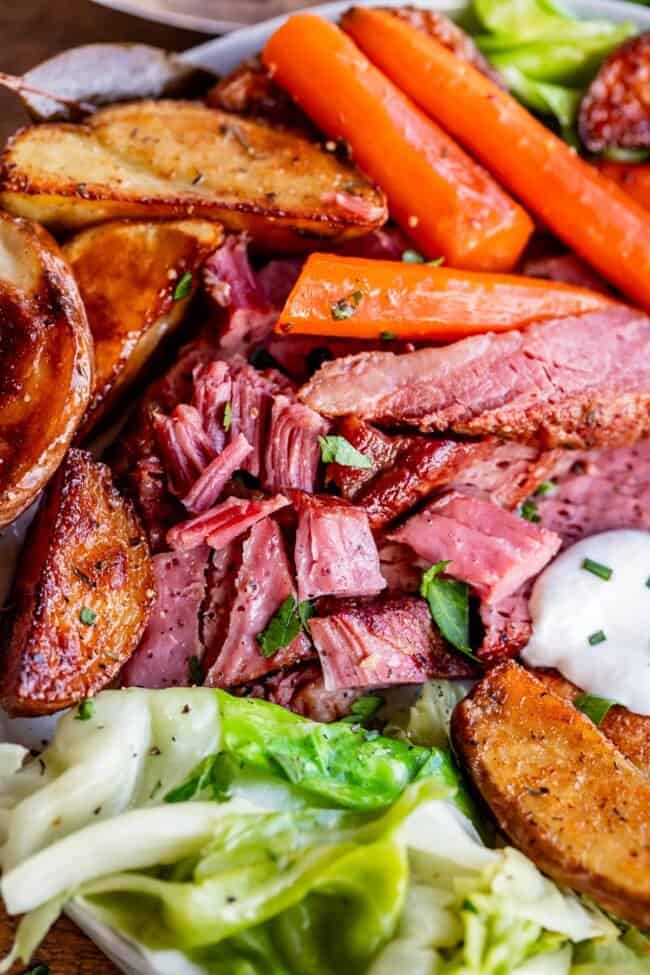 corned beef recipe, shredded on a plate with cabbage, carrots, and potatoes.