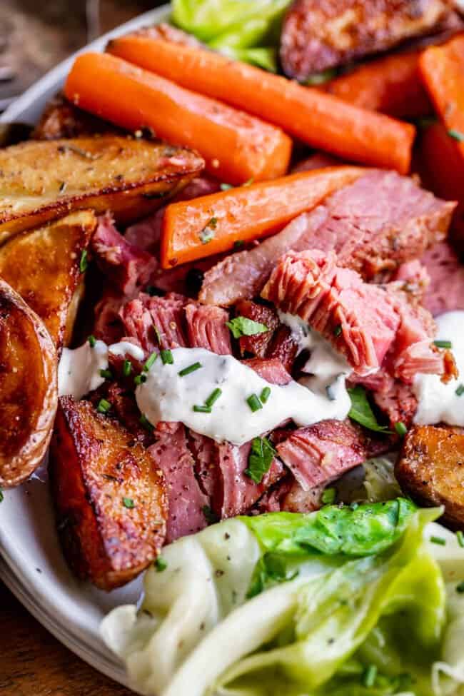 corn beef and cabbage on a plate with potatoes and carrots and cabbage.