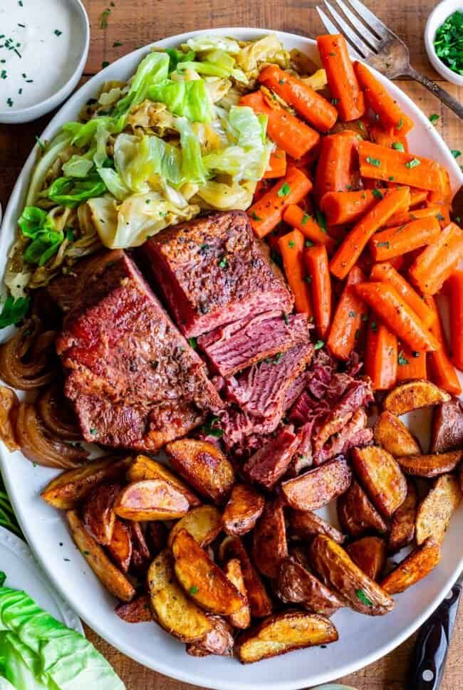 corned beef and cabbage on a platter with carrots and potatoes.