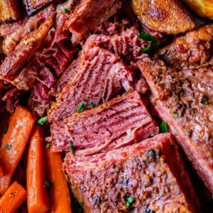 crockpot corned beef half sliced from overhead with carrots and potatoes