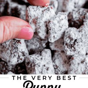 pin for puppy chow recipe, fingers holding chunky muddy buddies with pink text