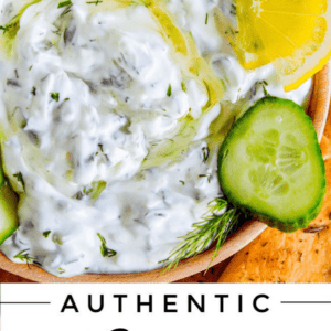 Greek tzatziki sauce in a wooden bowl with lemons and cucumbers.