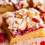 picture of raspberry shortbread bars shot from the side with jam and almond streusel.