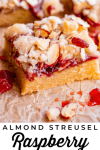 raspberry crumble bars with almond streusel on parchment paper.