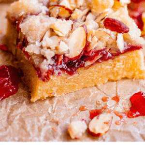 raspberry crumble bars with almond streusel on parchment paper.