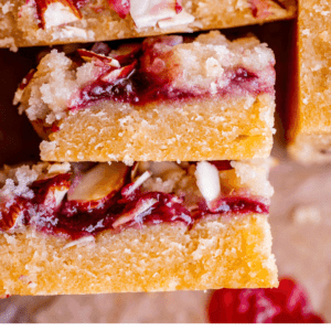 stacked up raspberry shortbread bars with jam.