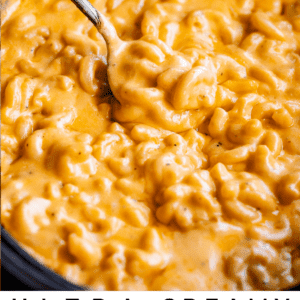 spoon lifting mac and cheese from a black crock pot.