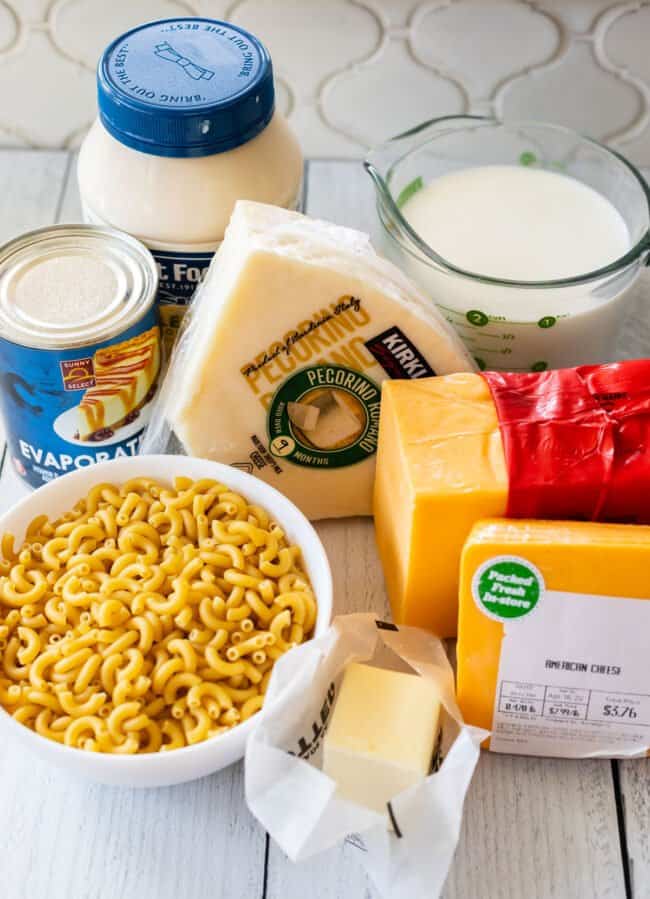 all the ingredients you need for crockpot macaroni and cheese, set on a counter.
