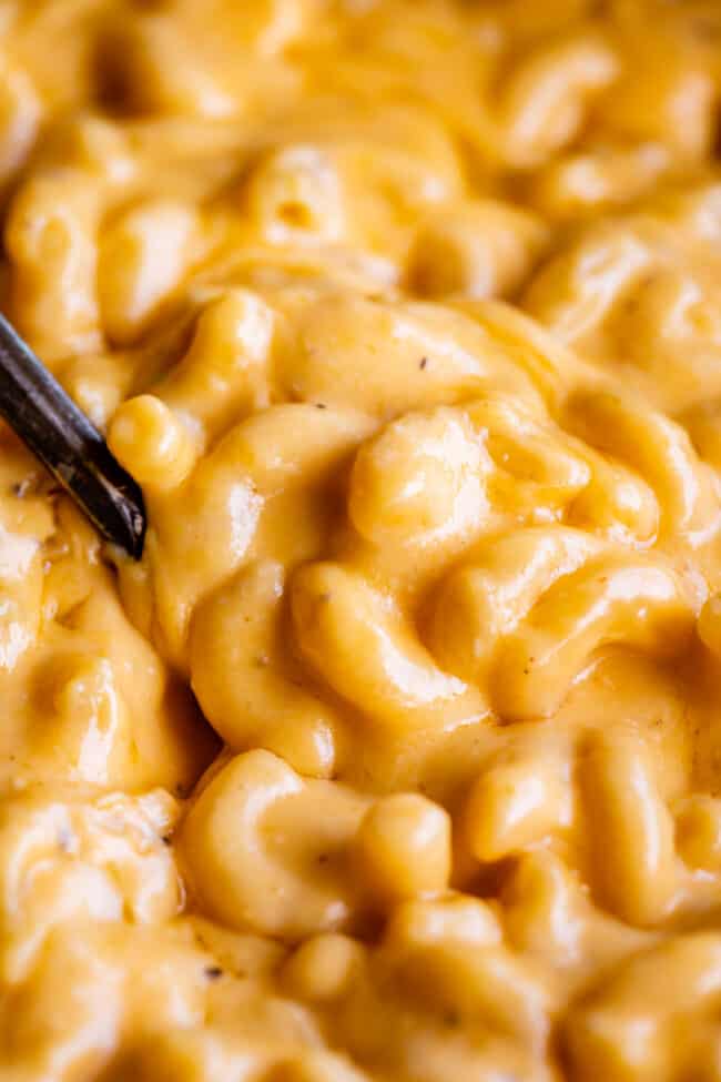 close up of best slow cooker mac and cheese with spoon digging in.