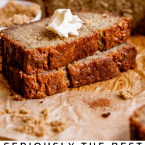 A sliced loaf of sour cream banana bread with a dollop of whipped cream on one slice, sitting on brown parchment paper. Text reads: Seriously the Best Sour Cream Banana Bread - The Food Charlatan.