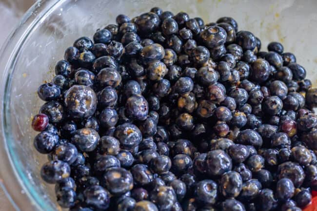 blueberry pie filling macerating in a bowl with sugar.