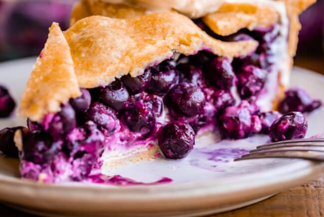 showing off layer of cream cheese on bottom of blueberry pie.