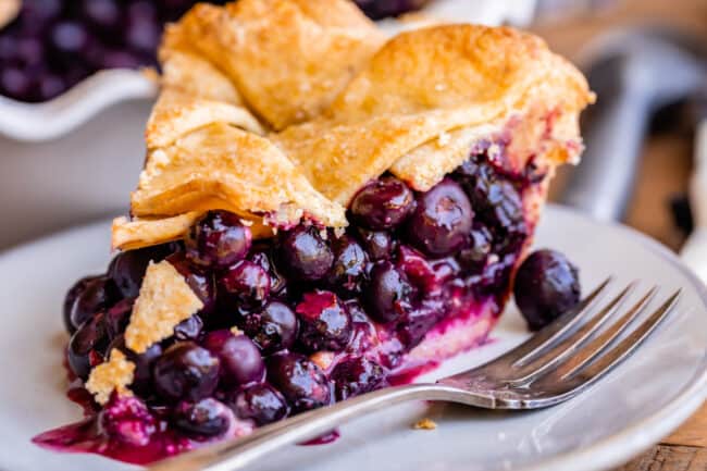 recipe blueberry pie with a fork on a plate.