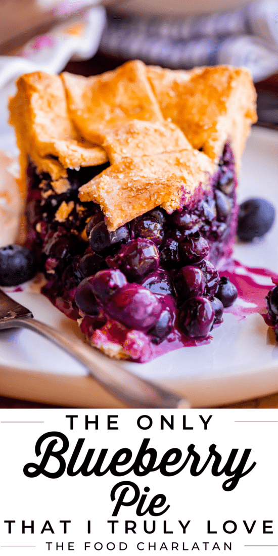 slice of best blueberry pie recipe on a white plate with fork.