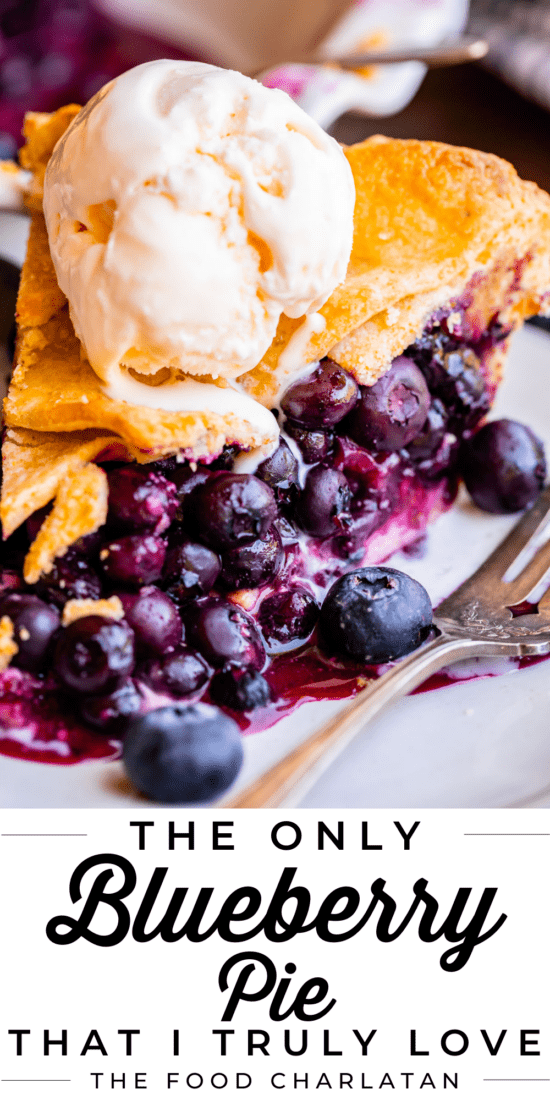 messy slice of blueberry pie on a plate topped with ice cream.