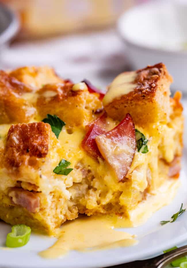 Eggs benedict breakfast casserole with hollandaise sauce on plate.