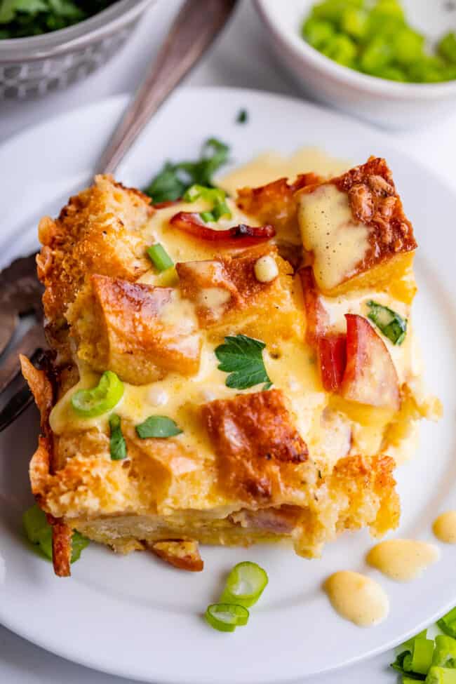 Overhead shot of egg benedict casserole on white plate with fork.