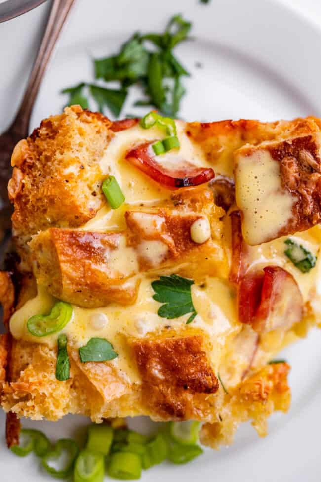 Close up overhead of overnight eggs benedict casserole on white plate with fork.