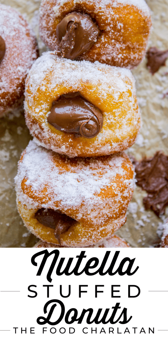 Nutella filled donuts lined up on parchment paper.