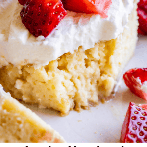 A close-up of a slice of tres leches cake topped with whipped cream and fresh sliced strawberries, with the text, “truly the best tres leches cake I’ve ever had – The Food Charlatan,” at the bottom, showcasing its irresistible flavor.