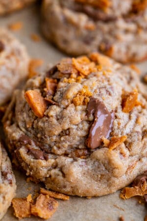 butterfinger bits cookie recipe with more crushed butterfinger on the pan.
