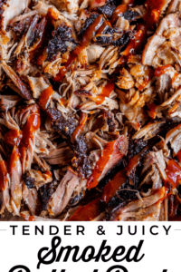 smoked pulled pork with blackened bark edges drizzled with bbq sauce.