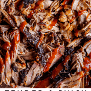 smoked pulled pork with blackened bark edges drizzled with bbq sauce.