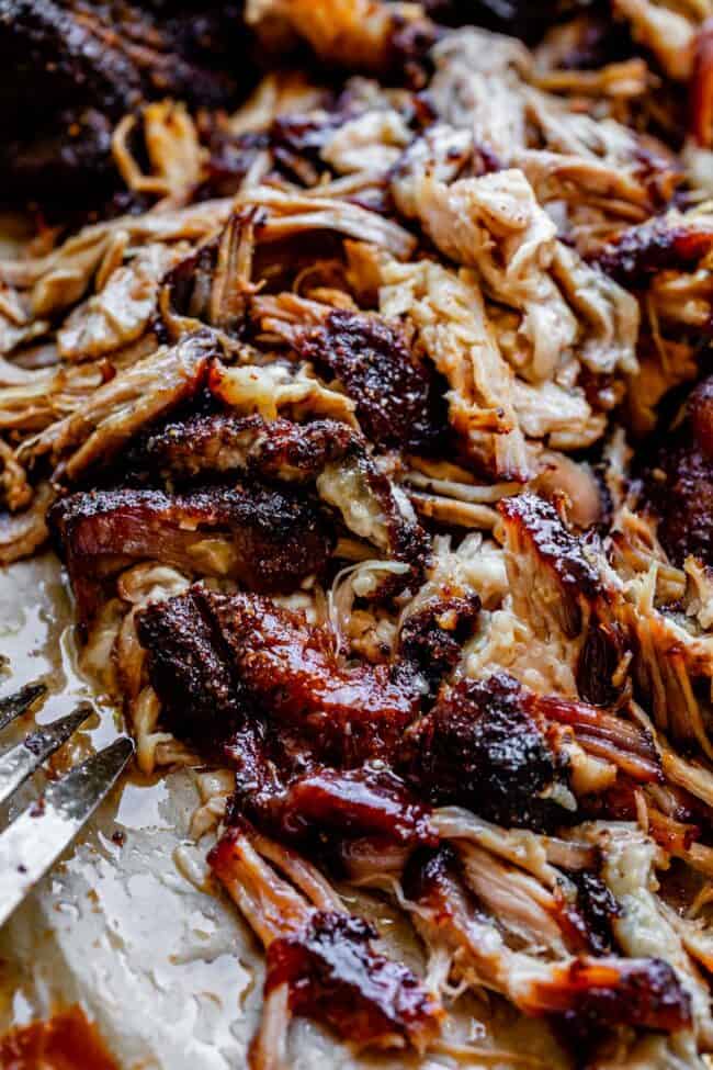 pulled pork made in the oven with blackened edges, shredded with a fork.