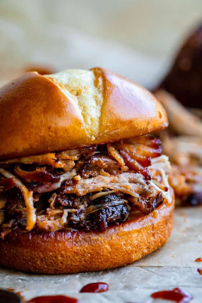oven pulled pork on a hamburger bun on parchment paper.